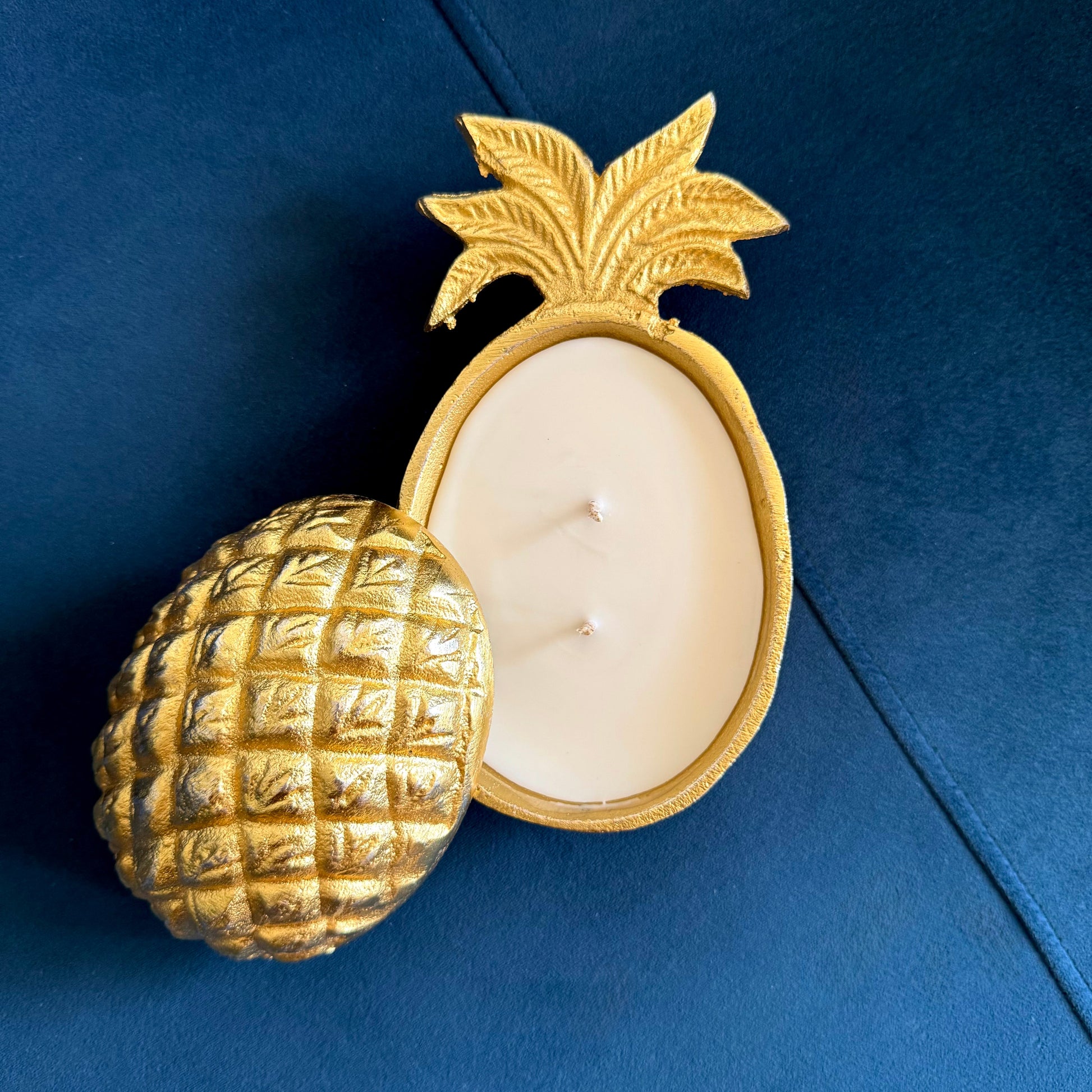 Gold pineapple-shaped candle holder with a white candle 